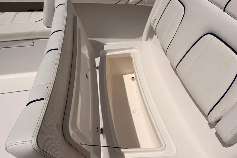 Slide: The Image of 2016 Regulator 34 boat with open storage compartment and cushioned seating. - 28