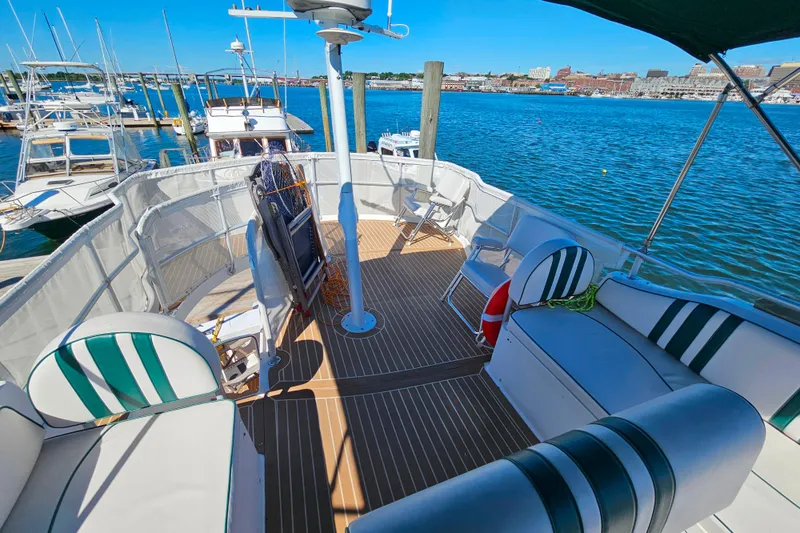 Slide: The Image of 2000 Mainship 39 Trawler deck with seating, overlooking marina and waterfront views. - 26