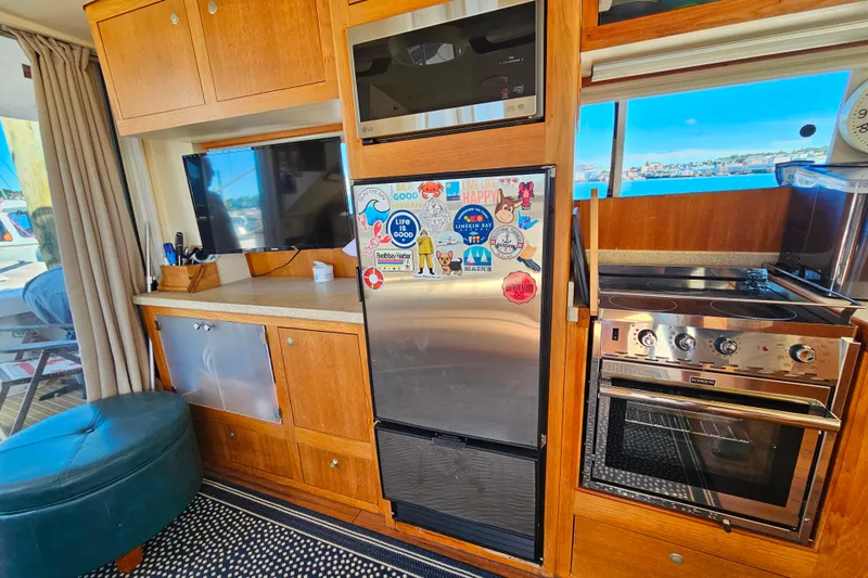 Slide: The Image of Mainship 39 Trawler 2000 interior with kitchen, fridge, and scenic window view. - 40