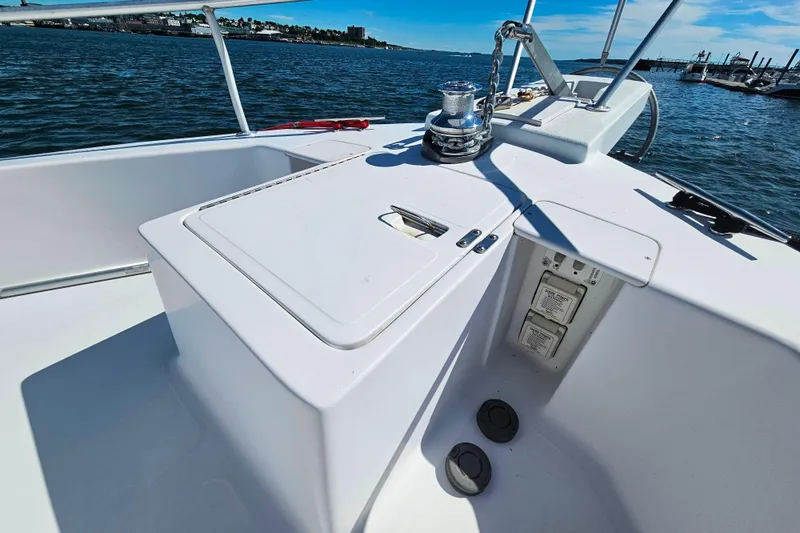 Slide: The Image of 2001 Mainship 39 Trawler deck with winch, ocean view, and marina background. - 8
