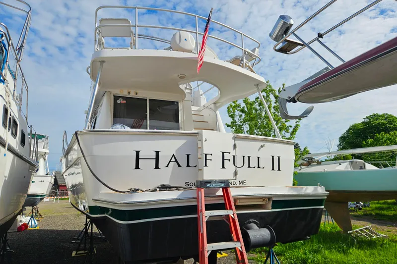 Slide: The Image of 2000 Mainship 39 Trawler "Half Full II" docked, featuring a ladder and American flag. - 53
