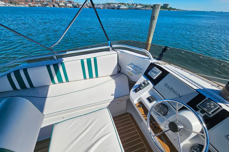 Slide: The Image of Cockpit of 2000 Mainship 39 Trawler with Garmin navigation, overlooking serene waterfront. - 27