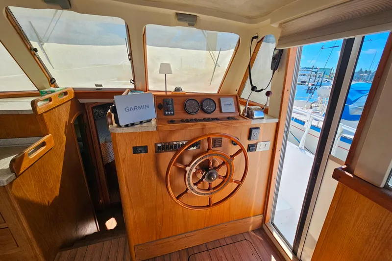 Slide: The Image of Interior helm of 2000 Mainship 39 Trawler with wooden steering wheel and Garmin navigation. - 50
