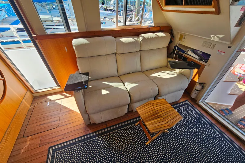 Slide: The Image of Interior of 2000 Mainship 39 Trawler with beige sofa, wooden flooring, and nautical decor. - 16