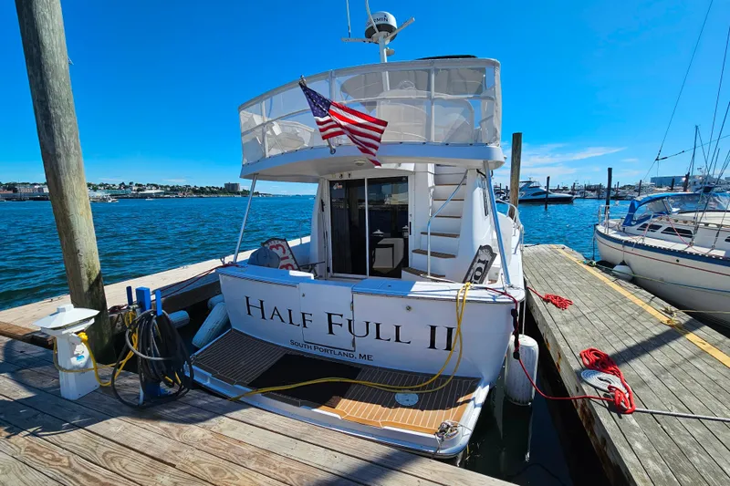 Slide: The Image of 2001 Mainship 39 Trawler docked, displaying American flag, named "Half Full II". - 7