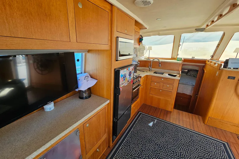 Slide: The Image of Interior of 2000 Mainship 39 Trawler with kitchen, TV, and cozy sleeping area. - 42