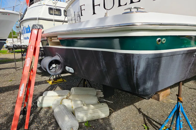 Slide: The Image of 2000 Mainship 39 Trawler on dry dock with ladder and fenders nearby. - 52