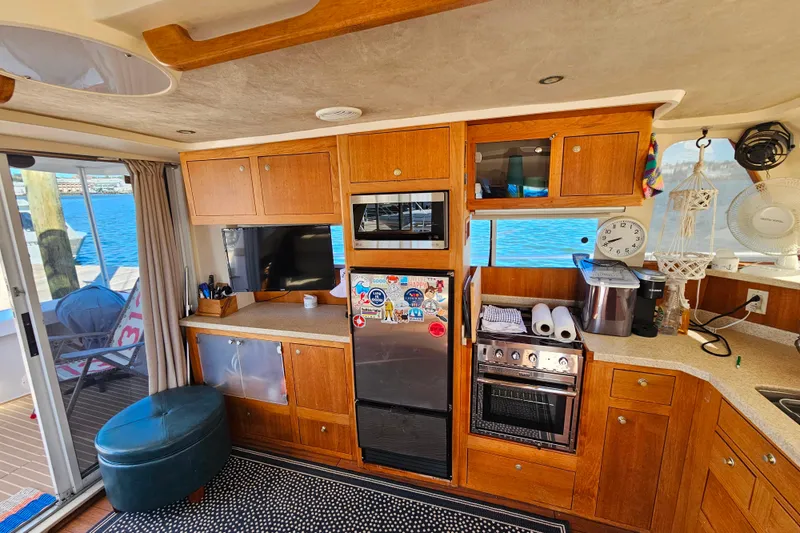 Slide: The Image of Interior of 2000 Mainship 39 Trawler with kitchen amenities and waterfront view. - 48