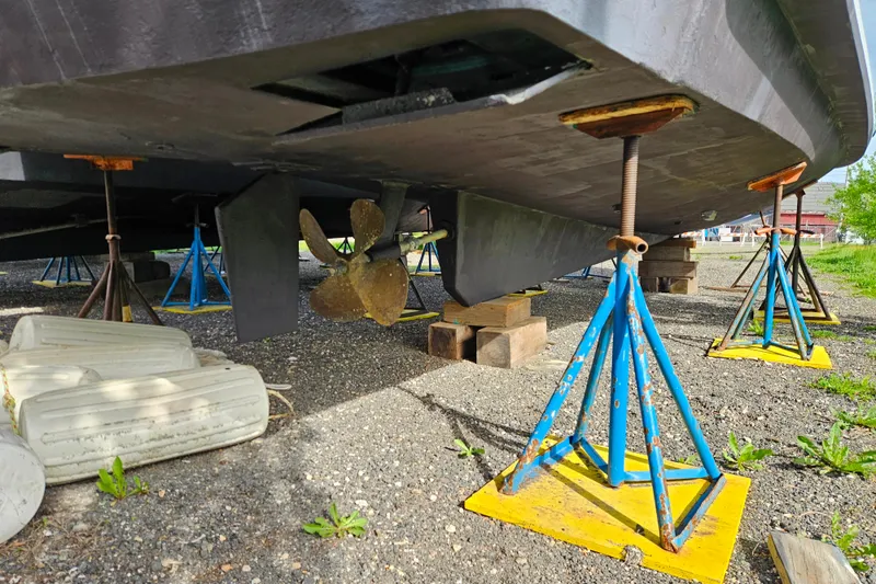 Slide: The Image of 2000 Mainship 39 Trawler on stands, showing propeller and hull details. - 51