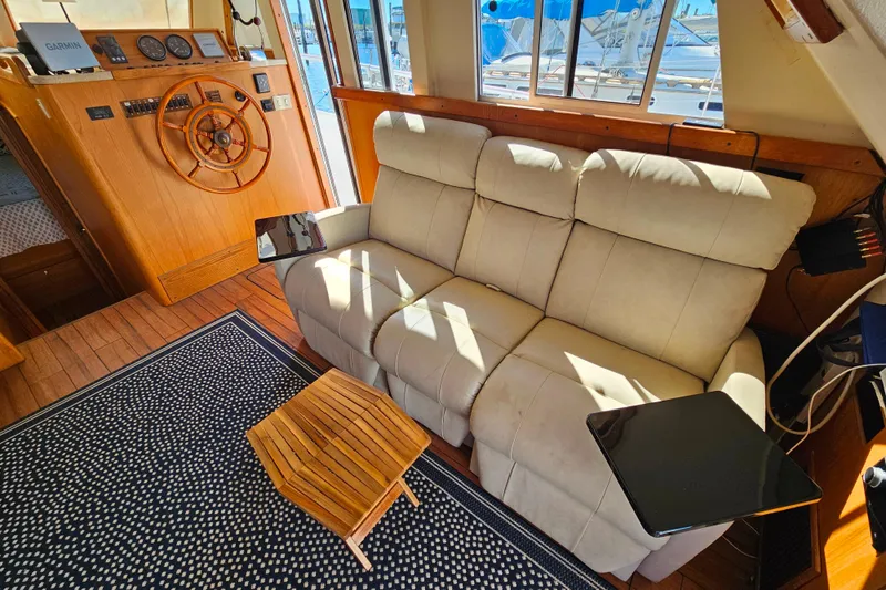 Slide: The Image of Interior of 2000 Mainship 39 Trawler with cozy seating and nautical decor. - 38
