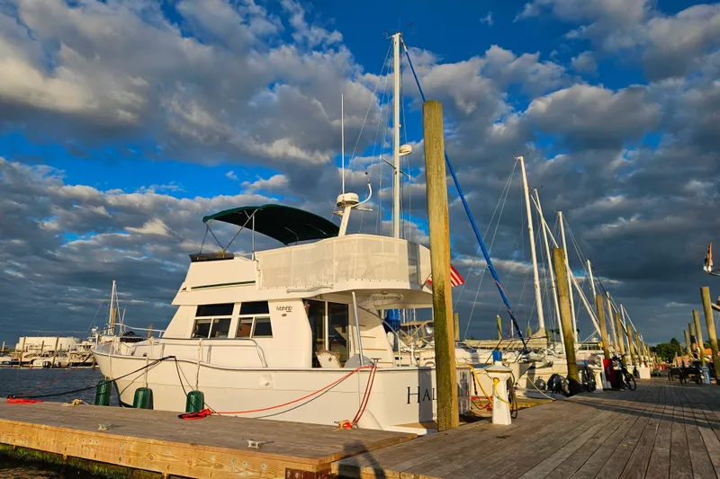 Slide: The Image of 2001 Mainship 39 Trawler docked under a vibrant, cloudy sky. - 5