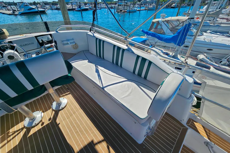 Slide: The Image of Cockpit of 2000 Mainship 39 Trawler with striped seating, overlooking marina. - 30