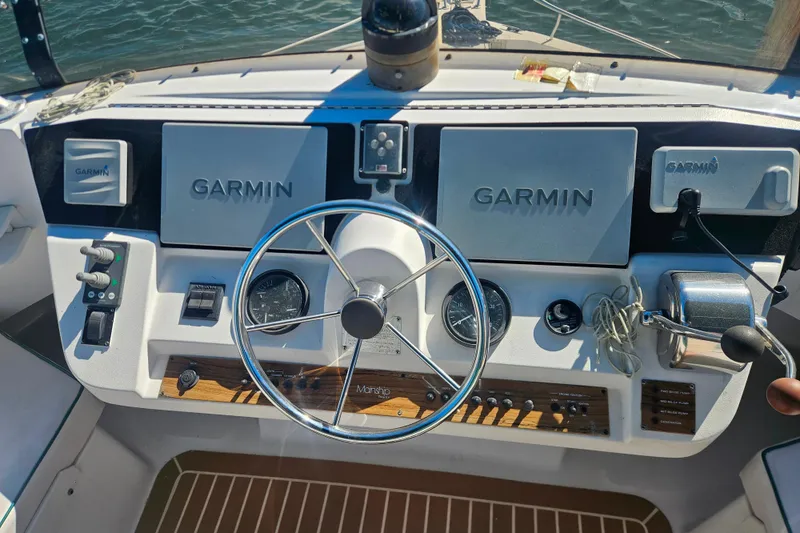 Slide: The Image of Helm of 2000 Mainship 39 Trawler with Garmin navigation systems and steering wheel. - 33
