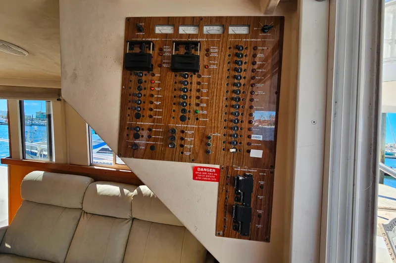 Slide: The Image of Electrical panel inside 2000 Mainship 39 Trawler, featuring switches and gauges. - 19