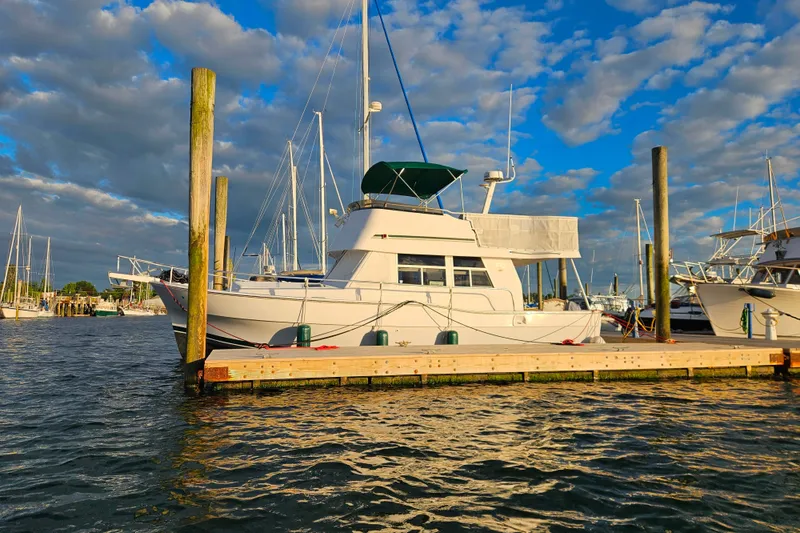Slide: The Image of 2001 Mainship 39 Trawler docked at marina under vibrant blue sky. - 2