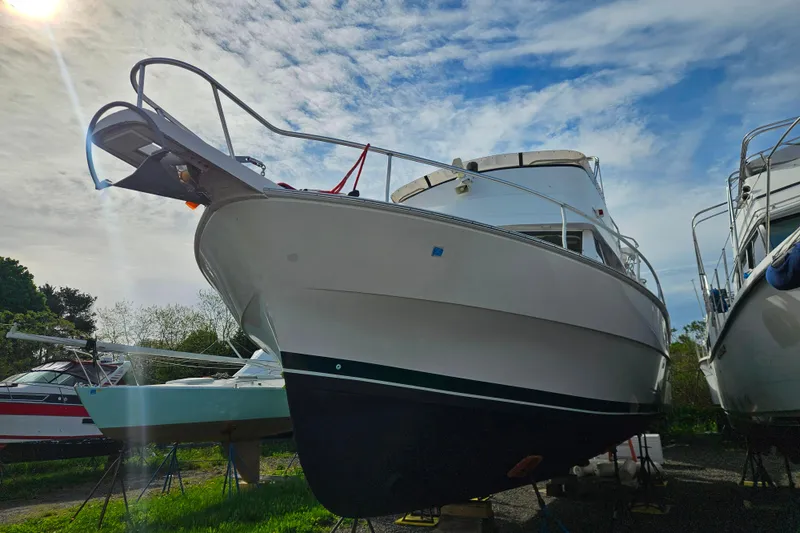 Slide: The Image of 2000 Mainship 39 Trawler on land, under a partly cloudy sky. - 54