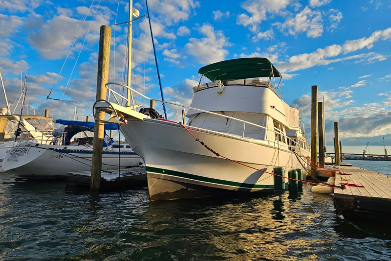 Slide: The Image of 2001 Mainship 39 Trawler docked at marina under a vibrant blue sky. - 4