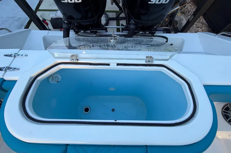 Slide: The Image of An open, oval fish tank on a boat with two outboard motors. - 18