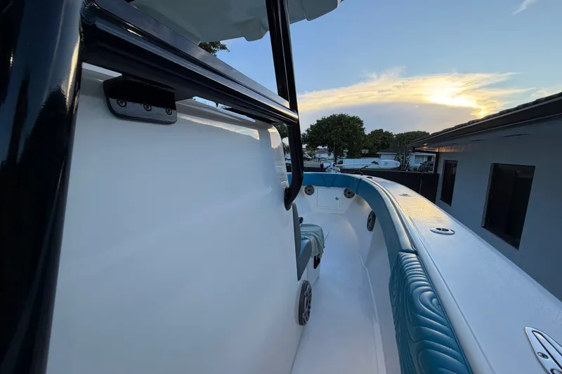 Slide: The Image of 2023 Sea Tech 33 boat interior with blue seating, captured at sunset. - 48