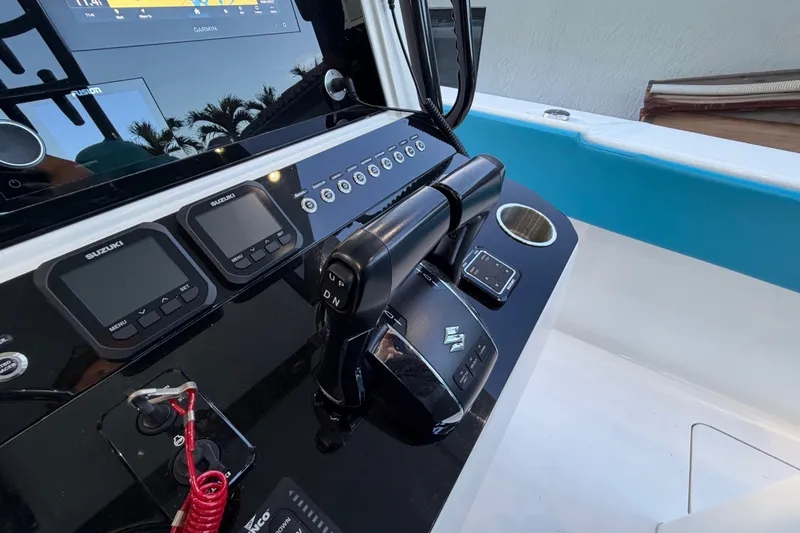 Slide: The Image of Control panel of a 2023 Sea Tech 33 boat with Suzuki displays and Garmin navigation. - 38