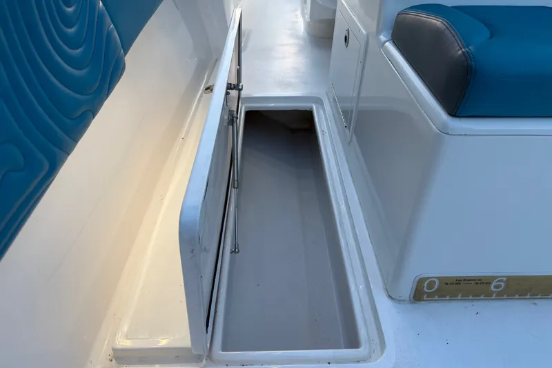 Slide: The Image of 2023 Sea Tech 33 boat storage compartment with blue seating and open hatch. - 25
