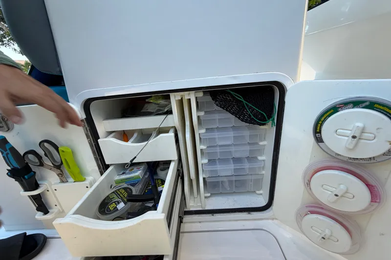 Slide: The Image of Fishing tackle storage on 2023 Sea Tech 33 boat, featuring organized drawers and tools. - 30