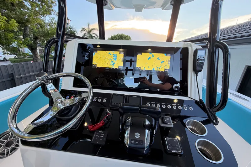 Slide: The Image of 2023 Sea Tech 33 boat dashboard with navigation screens and controls at sunset. - 33