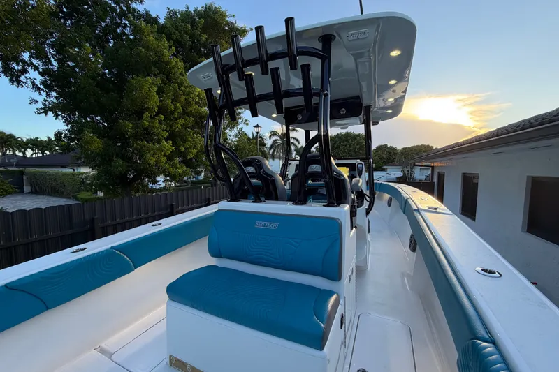 Slide: The Image of 2023 Sea Tech 33 boat with blue seating, sleek design, and modern features at sunset. - 16