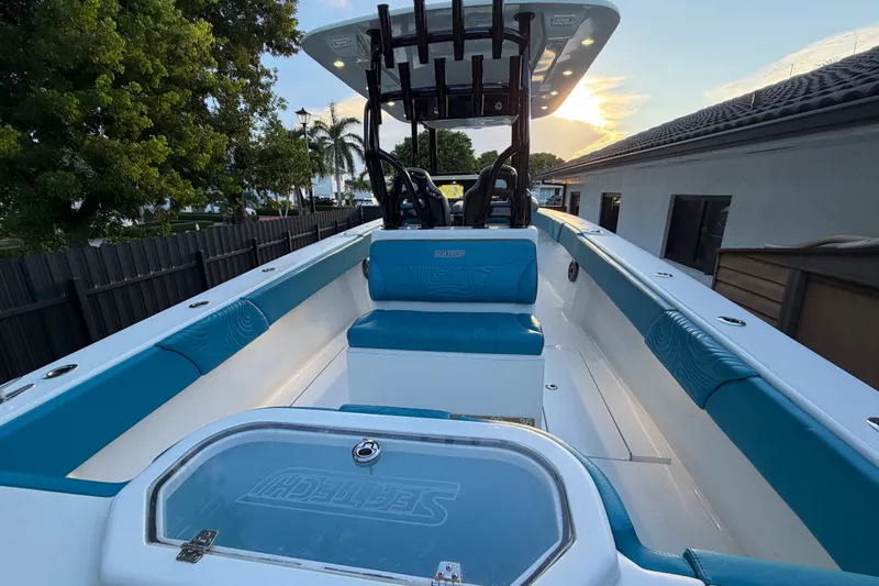 Slide: The Image of 2023 Sea Tech 33 boat interior with blue seating and sleek design at sunset. - 15