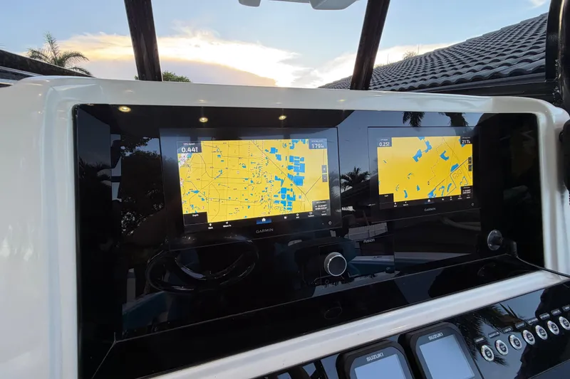 Slide: The Image of 2023 Sea Tech 33 boat dashboard with dual Garmin navigation screens at sunset. - 42