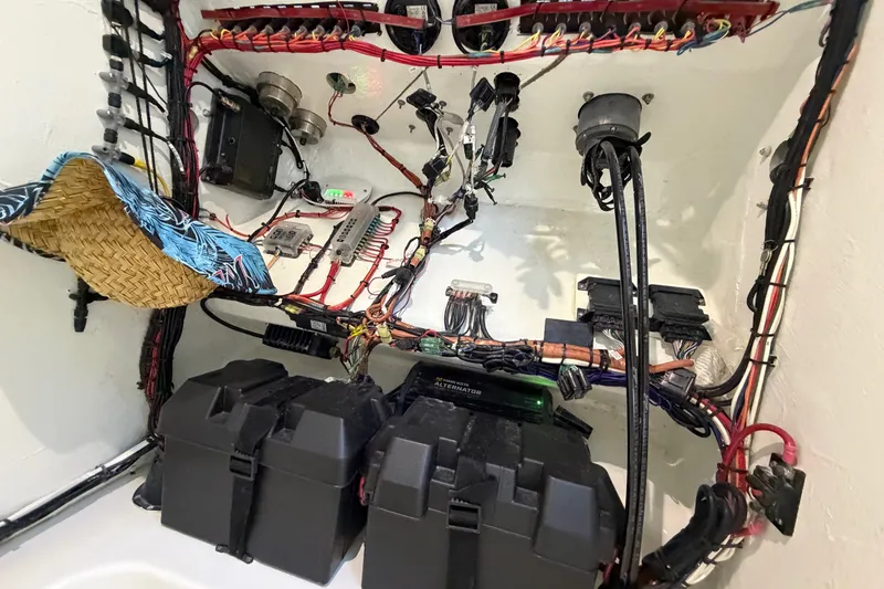 Slide: The Image of Electrical wiring and components inside a 2023 Sea Tech 33 boat, showcasing organized cables and battery boxes. - 53