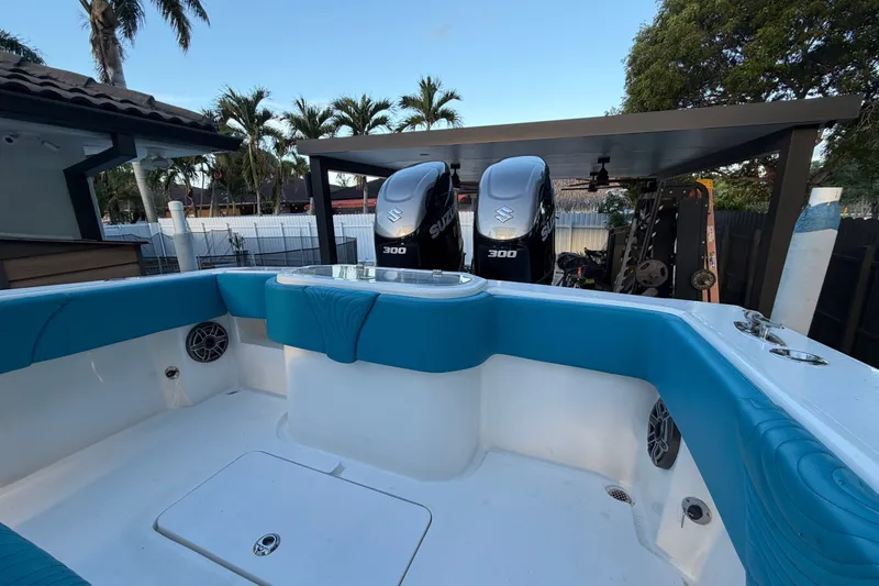 Slide: The Image of 2023 Sea Tech 33 boat with twin Suzuki 300 engines, blue seating, and outdoor setting. - 17