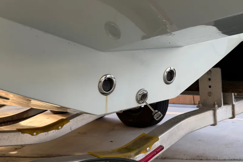 Slide: The Image of 2023 Sea Tech 33 boat hull on trailer, showcasing drain plugs and fittings. - 6