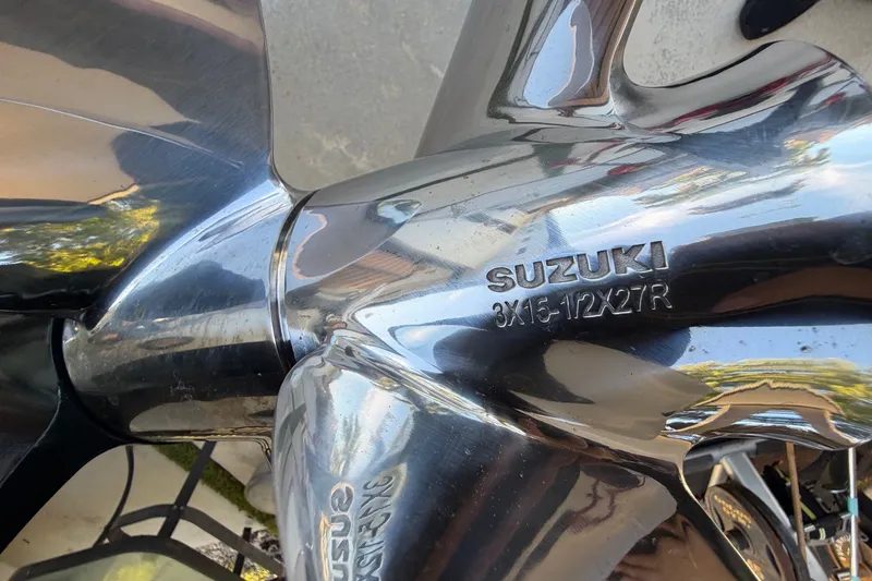 Slide: The Image of Close-up of a shiny Suzuki propeller with engraved details. - 10
