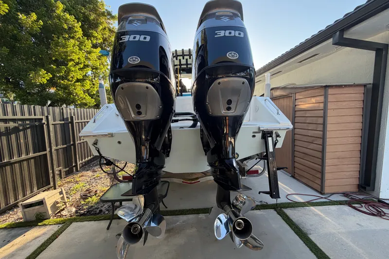 Slide: The Image of Twin 300 horsepower engines on a 2023 Sea Tech 33 boat, parked outdoors. - 2