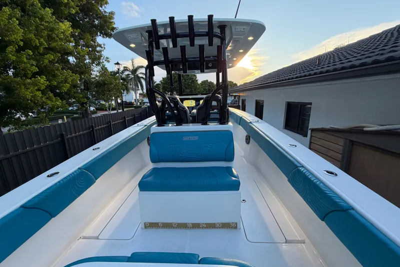 Slide: The Image of 2023 Sea Tech 33 boat interior with blue seating, docked at sunset. - 14