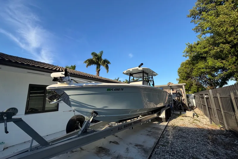 The Image of 2023 Sea Tech 33 boat on trailer, parked beside a house with palm trees. - 0