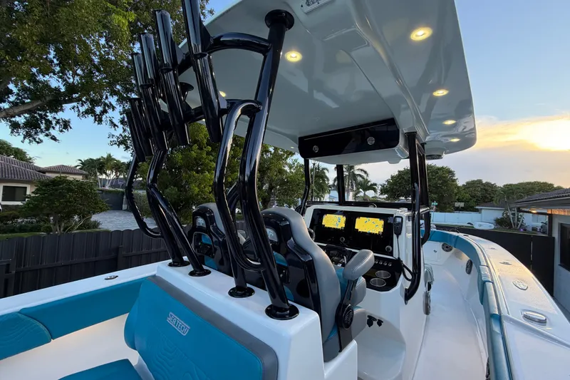 Slide: The Image of 2023 Sea Tech 33 boat interior with advanced navigation systems and rod holders at sunset. - 29