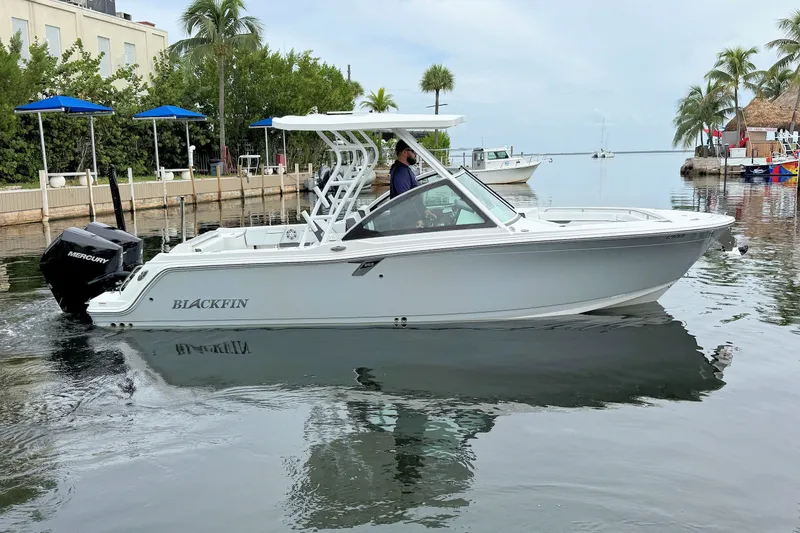 The Image of 2022 Blackfin 252 DC boat on calm water near a tropical dockside setting. - 1