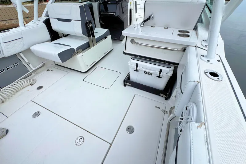 Slide: The Image of 2022 Blackfin 252 DC boat interior with seating, storage, and Yeti cooler. - 15