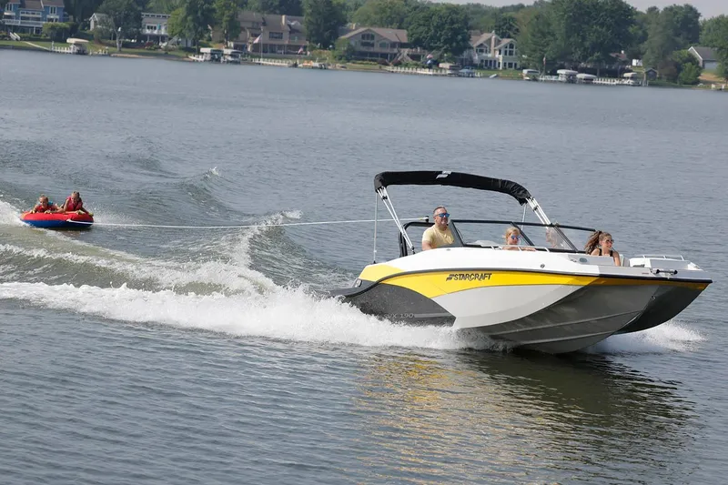 Slide: The Image of Manufacturer Provided Image: 2026 Starcraft SVX 190 DC OB boat towing people on a lake, creating waves. - 3