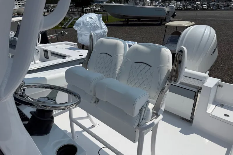 Slide: The Image of 2027 Sportsman Open 232 Center Console boat with dual white cushioned seats and steering wheel. - 5