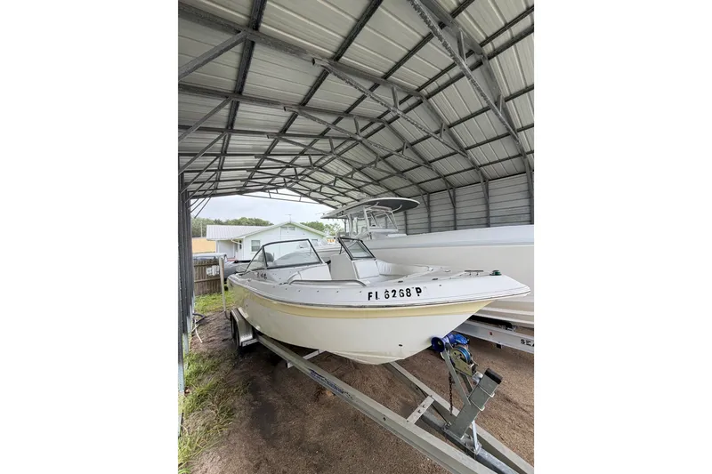 Slide: The Image of 2009 Sea Fox 236 Dual Console boat stored under a metal canopy. - 14