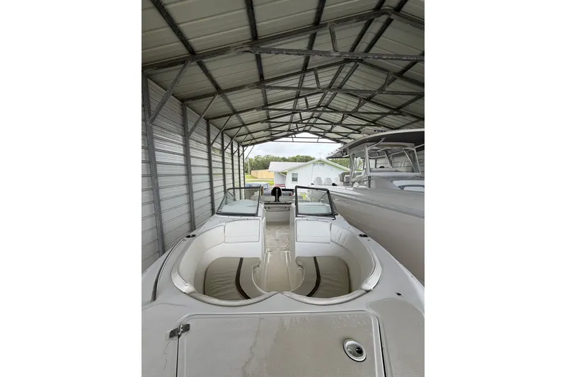 Slide: The Image of 2009 Sea Fox 236 Dual Console boat under metal shelter, showcasing spacious interior. - 13
