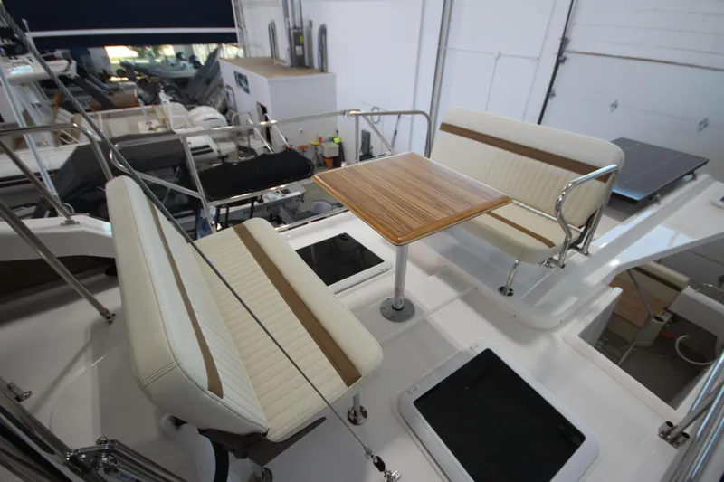 Slide: The Image of 2026 Ranger Tugs R-31 CB boat interior with seating and wooden table. - 25