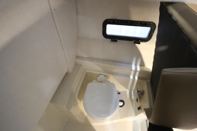 Slide: The Image of Interior of 2026 Ranger Tugs R-31 CB boat featuring a compact bathroom area. - 34