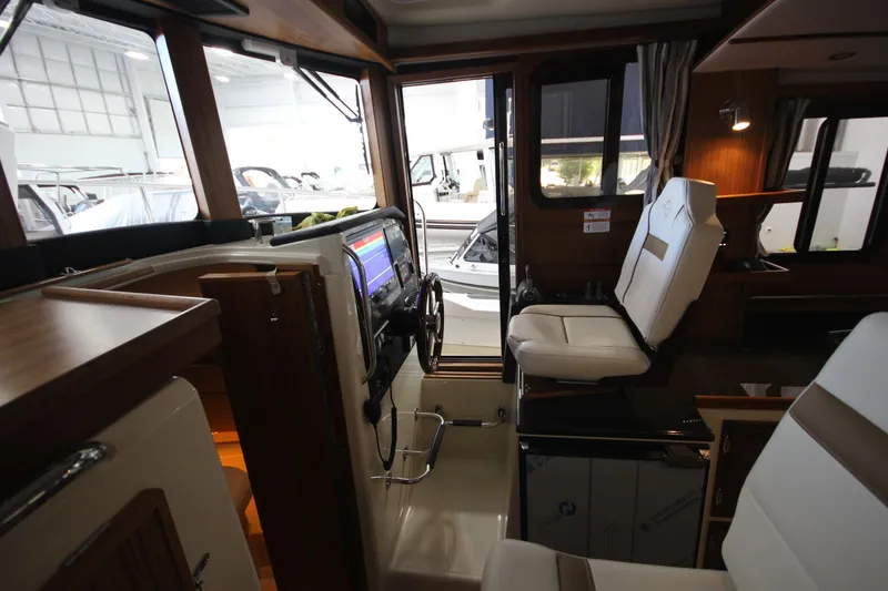 Slide: The Image of Interior of 2026 Ranger Tugs R-31 CB, featuring helm station and seating. - 46