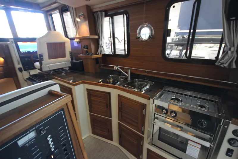 Slide: The Image of Interior of 2026 Ranger Tugs R-31 CB, featuring kitchen and control panel. - 42