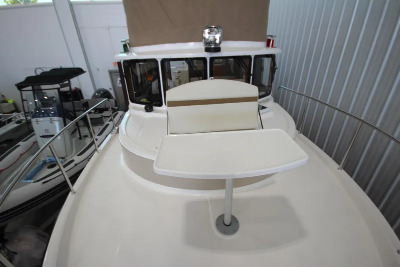 Slide: The Image of 2026 Ranger Tugs R-31 CB boat interior with table and seating in a showroom. - 60