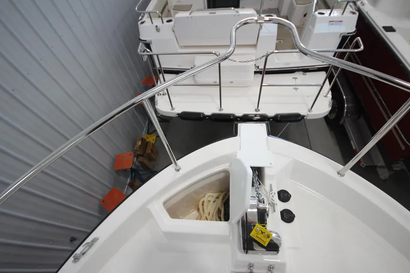 Slide: The Image of 2026 Ranger Tugs R-31 CB boat bow with anchor and railing in a showroom. - 65
